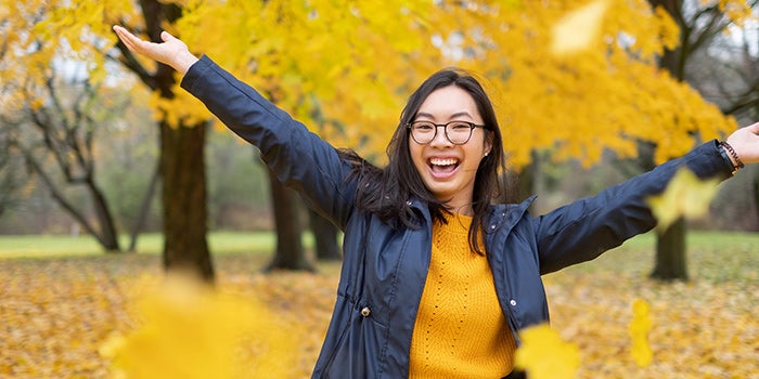 Student throwing leaves in the air